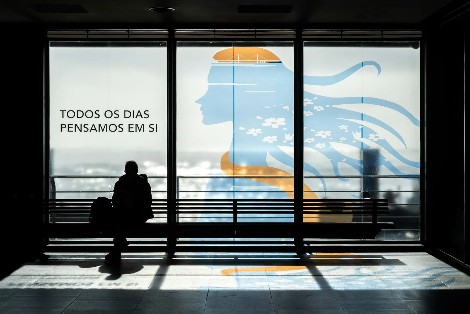 Colaborador confirmando login no celular com aplicativo autenticador ao lado de uma chave de segurança USB