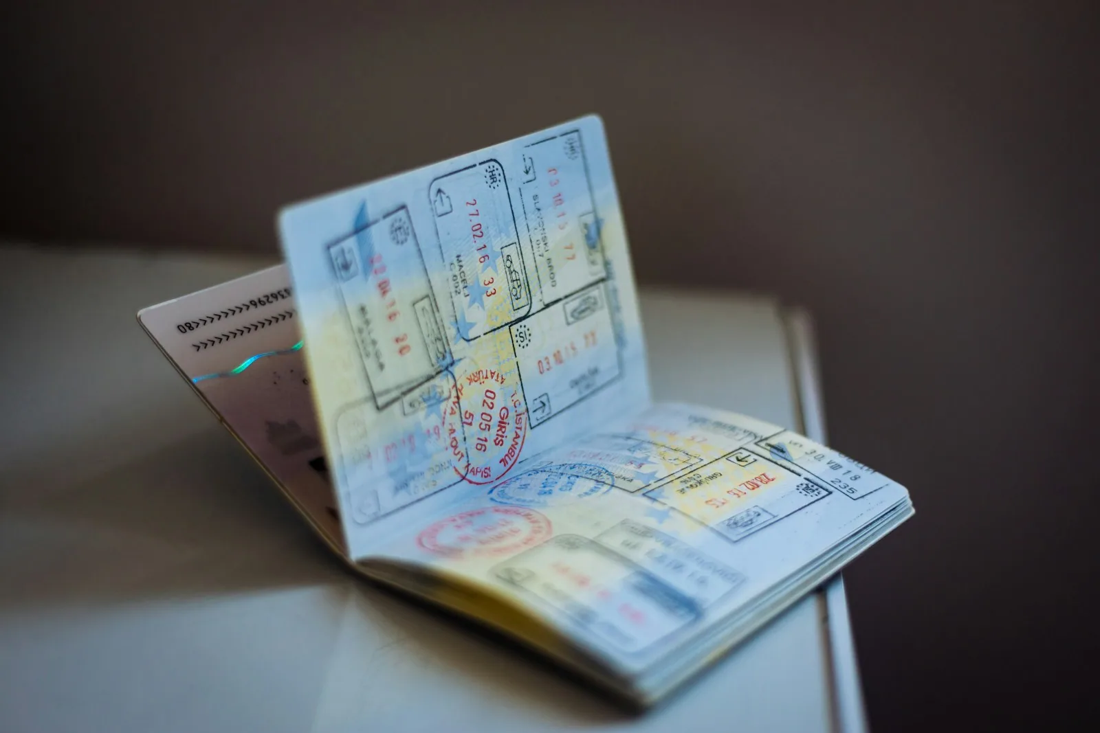 Ilustração sobre o H-1B visa em 2026: passaporte, formulário de visto dos EUA e um desenvolvedor trabalhando remotamente